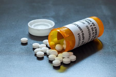 open bottle of oral sedation medication with some spilled out