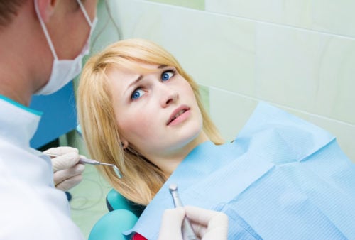anxious patient looking up at doctor from dental chair